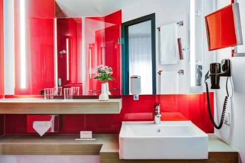 汉堡汉堡阿尔托纳城际酒店的浴室设有红色的墙壁和白色的盥洗盆。
