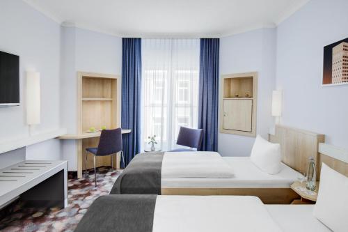 汉堡汉堡阿尔托纳城际酒店的酒店客房配有两张床和一张书桌