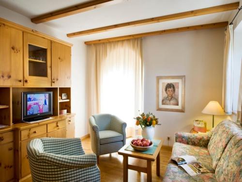 修希Residence Kampidell的客厅配有沙发、椅子和电视