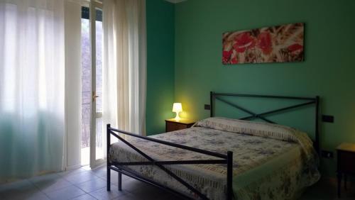 GarzenoB&B Zia Maria的一间卧室设有一张床和绿色的墙壁