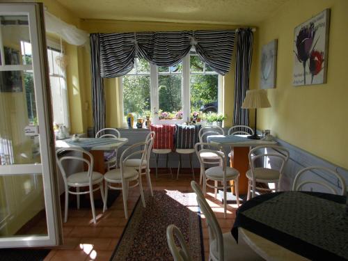 玛丽亚温泉流星别墅酒店的一间带桌椅的用餐室和窗户。
