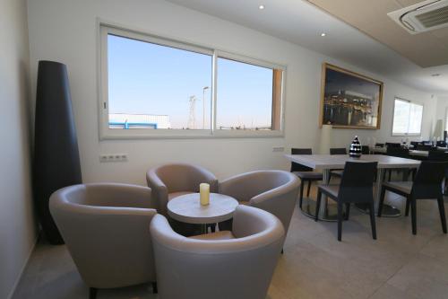 乐罗夫佩勒特斯餐厅酒店的用餐室配有桌椅和窗户