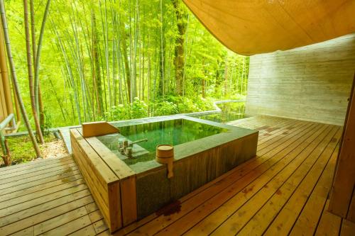 箱根金乃竹塔泽日式旅馆（仅限成人入住）的树底甲板上的热水浴池