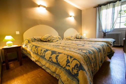 Sainte EngraceMaison Chantina的一间卧室配有两张床和一张带台灯的桌子