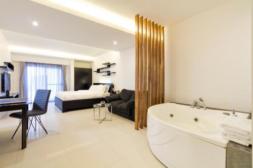 安吉利斯清风精品酒店的带浴缸的白色浴室和卧室