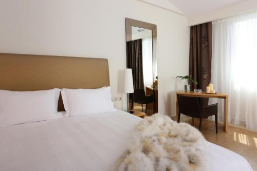 卡斯托里亚Chloe Luxury Hotel的卧室配有一张白色的床、一张桌子和一张书桌。