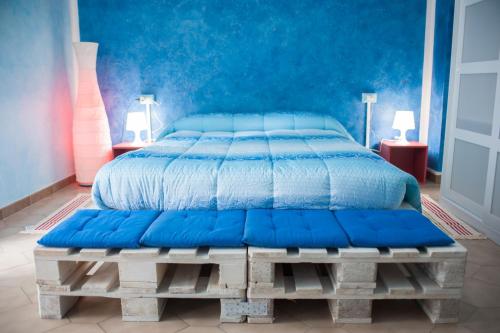 CastelfrentanoB&B Casa Tua的一张铺有蓝色毯子的木平台床