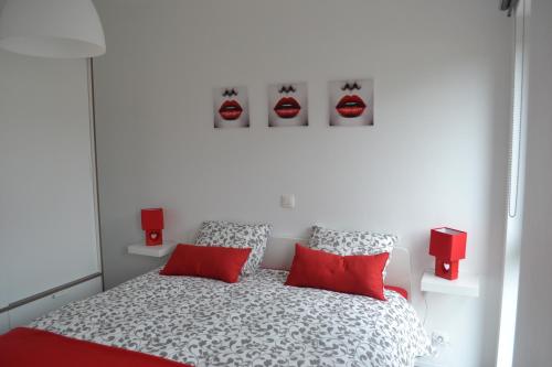 斯塔沃洛La boîte rouge的白色卧室配有红色枕头的床