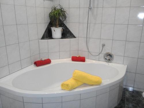 海利根布卢特Haus Benedikt的浴缸配有黄色和红色毛巾