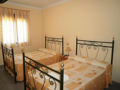 夸科斯德尤斯特Hostal Miraflor de las Cadenas的一间卧室设有两张床和窗户。