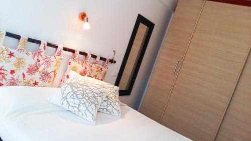 圣塔马利奈拉La Casetta Al Mare的卧室配有带枕头的白色床和衣柜。
