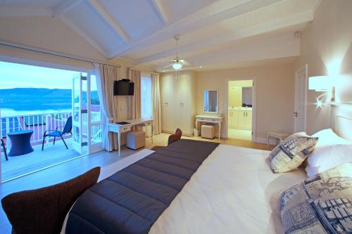 克尼斯纳Westhill Luxury Guest House的一间带大床的卧室和一个阳台