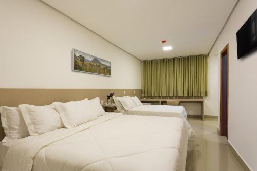 特林达迪Liguori Hotel的酒店客房设有两张床和窗户。