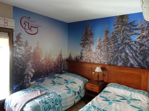 瓜达拉马冈萨雷斯旅馆 的一间卧室设有两张床,并拥有一幅树木壁画