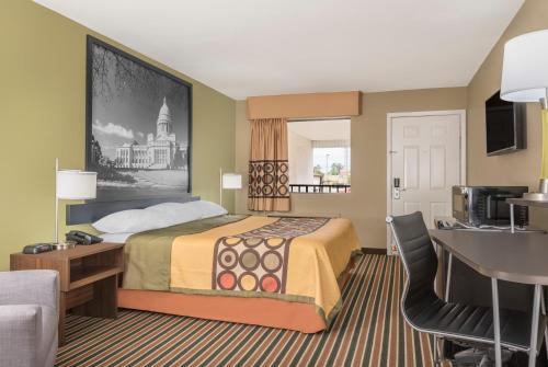 布赖恩特速8布莱恩特酒店的配有一张床和一张书桌的酒店客房