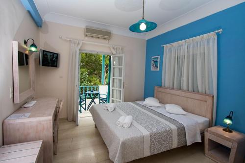 卡马利安德里亚斯酒店的一间卧室设有一张蓝色墙壁的床和一个阳台。