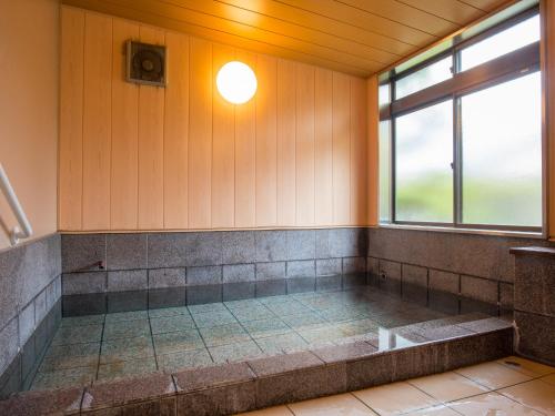 由布市由布之宿日式旅馆的客房设有带窗户的浴缸。