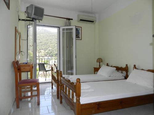 阿依亚埃夫菲亚Logaras Apartments的一间带两张床的卧室和一个阳台