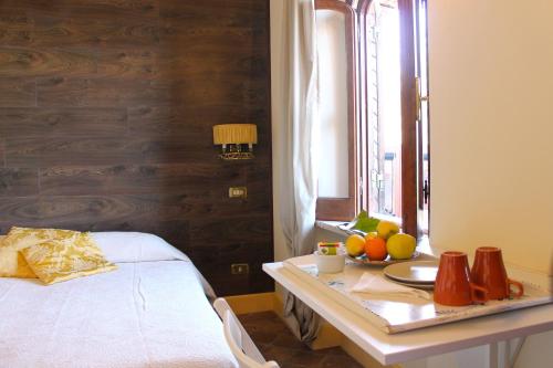 陶尔米纳Casa Via del Mare的一间房间,配有一张床和一张桌子,上面有水果