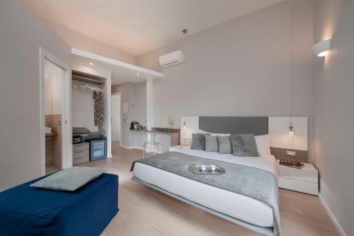 罗马斗兽场角旅馆的卧室配有一张白色大床和蓝色的搁脚凳