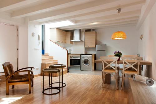 巴塞罗那MH里瑟欧公寓式酒店的厨房以及带桌椅的用餐室。