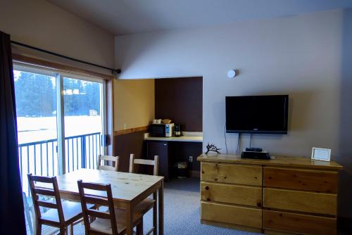 莱文沃思Leavenworth Camping Resort Lakeview Lodge 2的客厅配有桌子和梳妆台上的电视