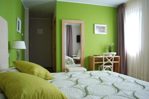 Elechas巴伊亚畔公寓式酒店的一间拥有绿色墙壁和一张大床的卧室