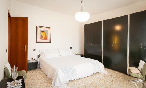 卢卡西莱斯特别墅酒店的卧室配有白色的床和黑色衣柜。