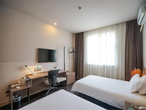 厦门锦江之星品上厦门集美大学国贸店的酒店客房配有两张床和一张书桌