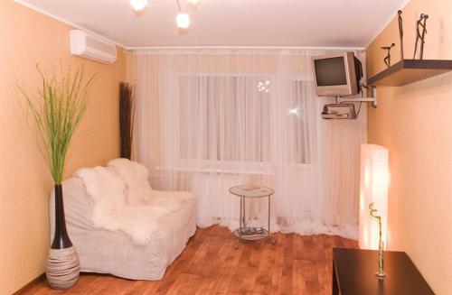 沃罗涅什MEGAPOLIS улица Никитинская 21-70的客厅配有白色椅子和电视