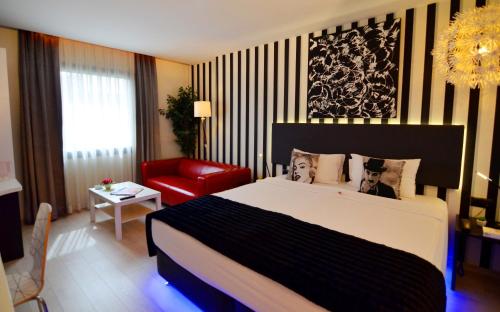 伊斯坦布尔Tempo Fair Suites的一间卧室配有一张大床和一张红色椅子