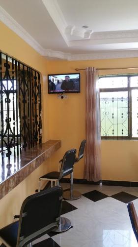 达累斯萨拉姆Mauya Executive Lodge的一间设有两把椅子和一台平面电视的等候室