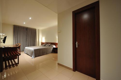 曼雷沙Hotel Els Noguers的卧室配有床、书桌和门