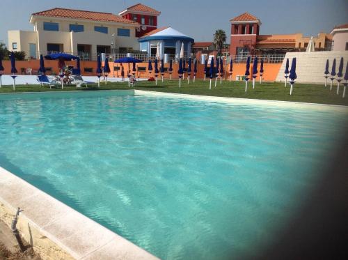 圣塔马利奈拉勒托里酒店的一个带蓝色椅子和遮阳伞的大型游泳池