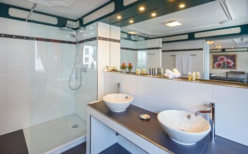卢塞恩鲁泽纳霍夫酒店的一间带两个盥洗盆和淋浴的浴室