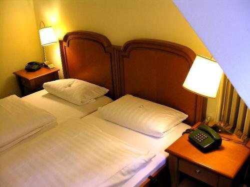 霍恩-巴特迈恩贝格西尔本穆勒森林酒店的一间卧室配有一张带电话的床和2个床头柜