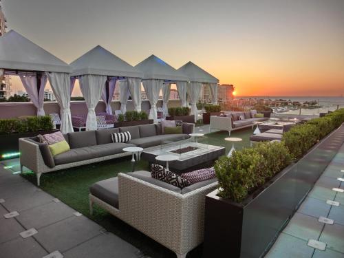 圣彼得堡伯奇伍德酒店的屋顶庭院配有沙发和桌子,享有日落美景。