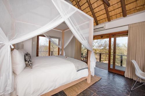 侯斯普瑞特Unembeza Boutique Lodge & Spa的一间卧室配有一张带天蓬的床