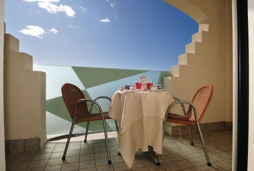 圣温琴佐Hotel Stella Marina的墙上的桌子和椅子