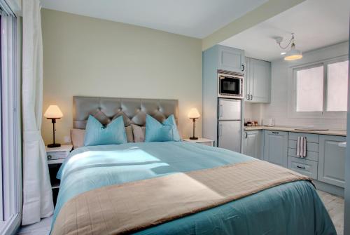 马拉加马拉加公寓的一间卧室配有一张带蓝色枕头的大床