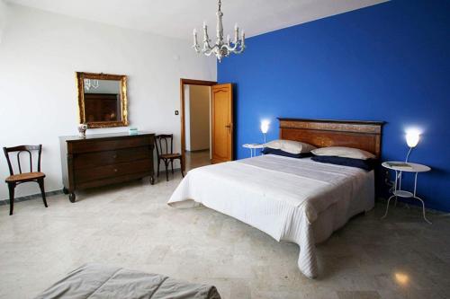 马泰拉微笑公寓的一间卧室设有一张大床和蓝色的墙壁