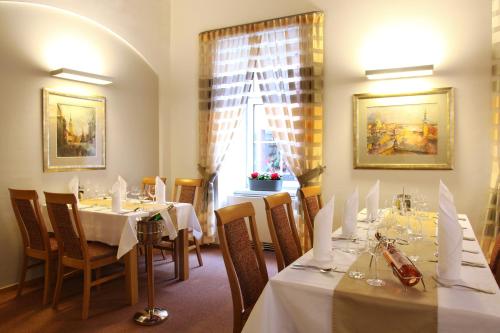 奥洛穆茨特里尼蒂酒店的一间带桌椅的用餐室和窗户。