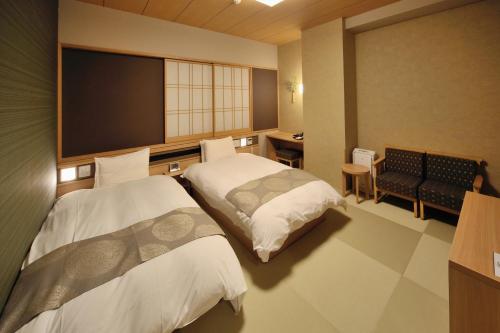 富山富山御宿野乃天然温泉经济型酒店的酒店客房设有两张床和一台平面电视。