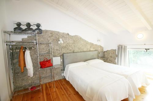 伊斯拉Villas San Roque Isla的一间卧室设有两张床和石墙