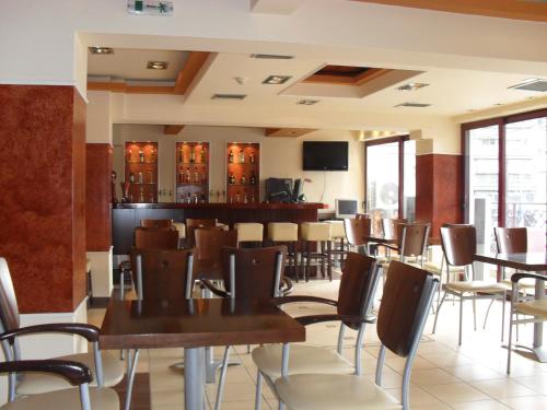 卡泰里尼奥林匹亚酒店的一间带桌椅的餐厅和一间酒吧