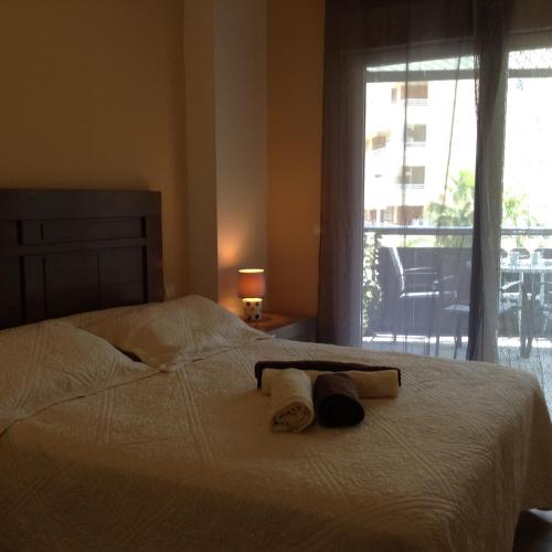 卡拉德费斯特拉特Benidorm La Cala Sidney的一间卧室配有带2条毛巾的床和窗户。