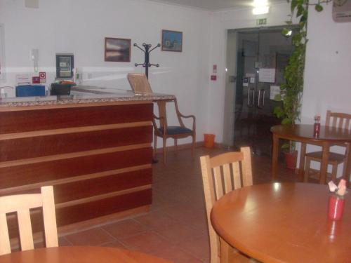 萨尔堡萨拉提亚酒店的厨房以及带桌椅的用餐室。