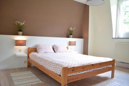 Yvoir德拉莫特堡度假屋的一间卧室配有一张带两个枕头的木床