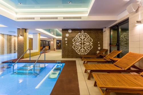 马马亚新辉煌酒店及Spa - 仅限成人（16岁以上）的游泳池,酒店内设有椅子和游泳池