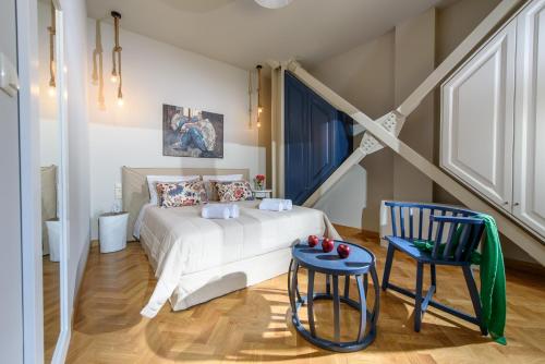海若克利欧坎地亚套房及客房公寓式酒店的卧室配有白色的床和蓝色椅子